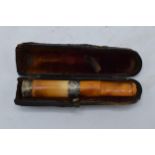 A cased cheroot / cigarette holder with 2 silver collars.