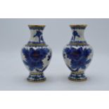 A pair of Japanese cloisonné vases with blue birds amongst foliage on a white background. 16cm tall.