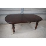 A large 19th century mahogany oval extending dining table on carved legs with casters and 2 spare