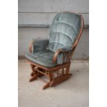 A vintage 20th century rocking arm chair / nursing chair made by Dutailier. 105cm tall.