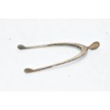 A pair of hallmarked silver sugar tongs in the form of a wishbone. 11.3 grams. Birm 1933.