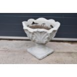 A concrete garden planter. 40cm tall. Chip to rear.