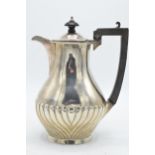 A hallmarked silver coffee pot with swirling decoration to bottom with ebonised handle. Gross weight