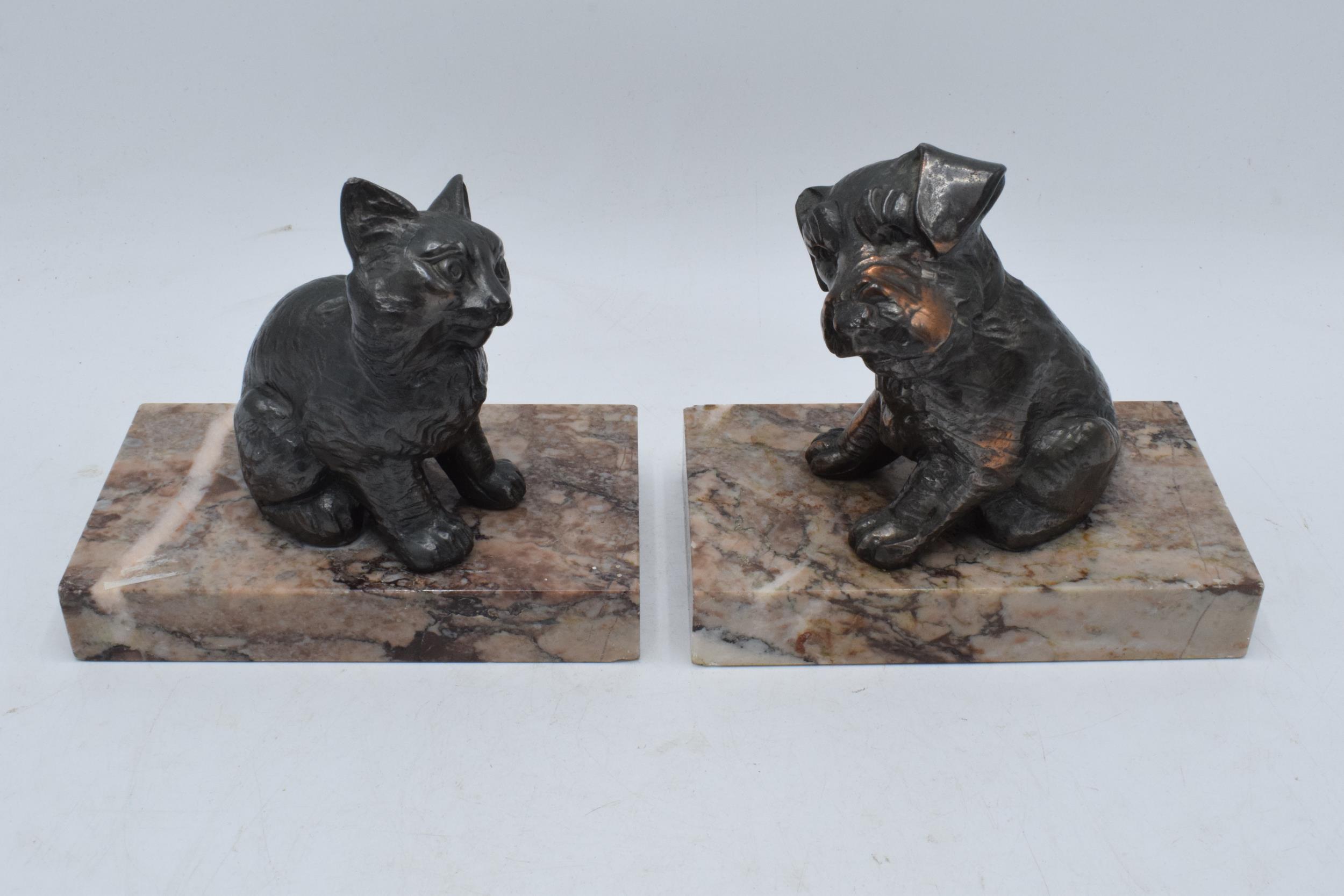 A pair of French Art-Deco bookends on marble plinths showing a cat and a dog (2). 14cm long.