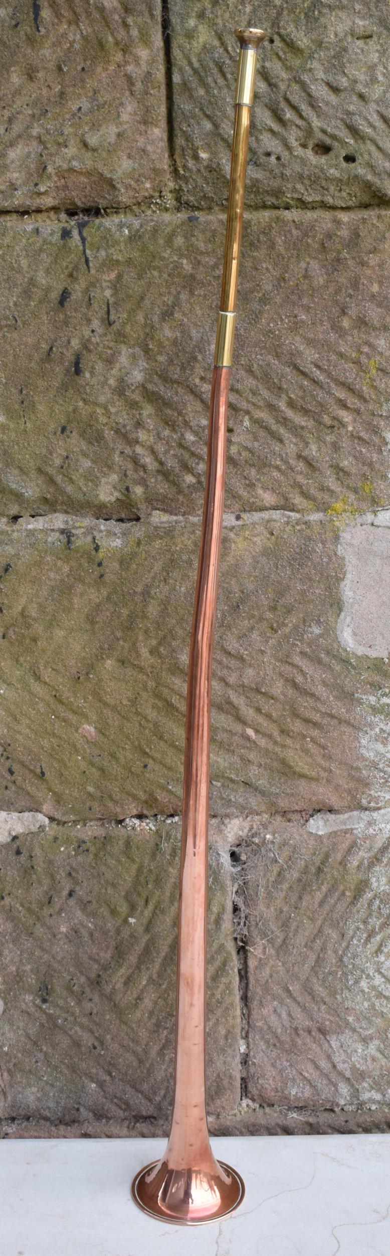Victorian copper hunting horn with brass mouthpiece and neck. 91cm tall. In good condition with some