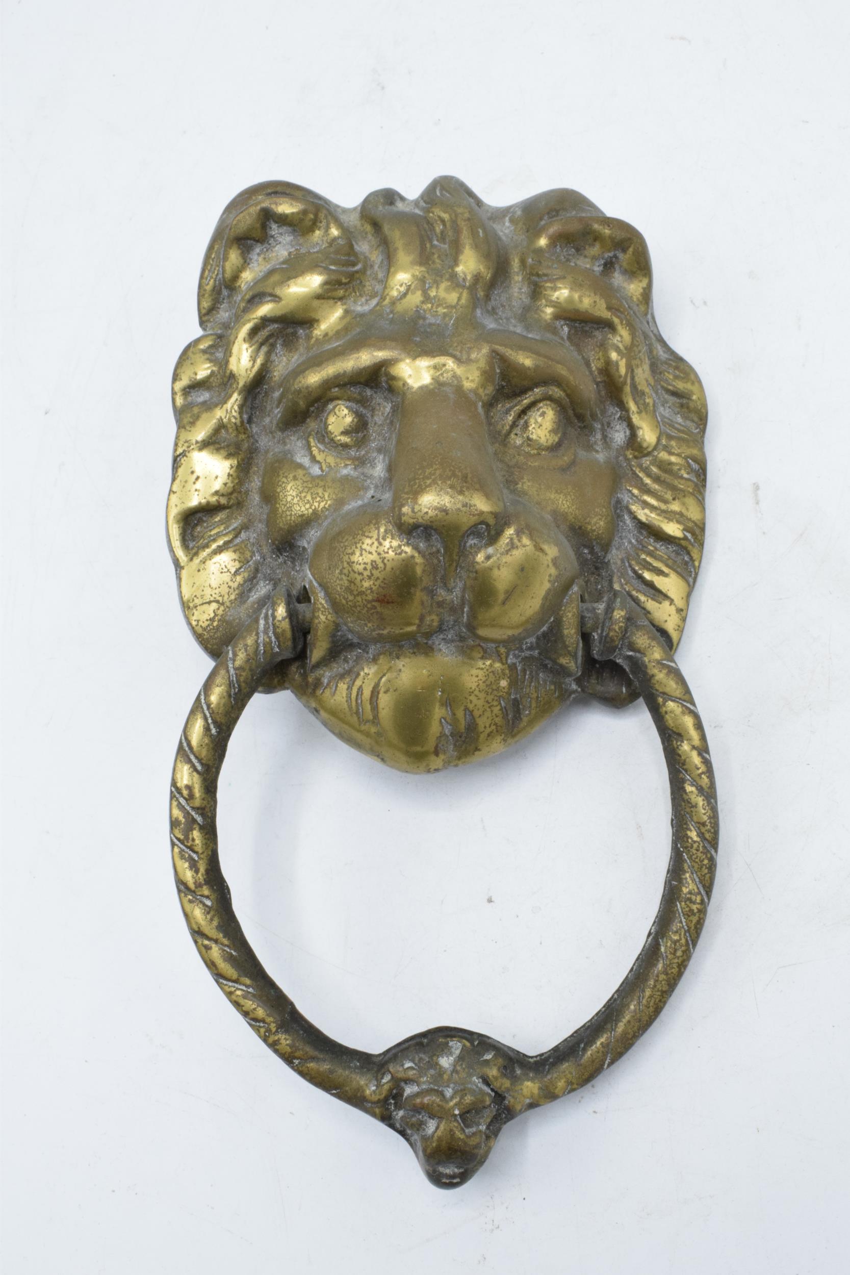 Antique cast brass door knocker in the form of a lion's head. 21cm long including hoop.