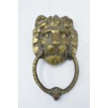 Antique cast brass door knocker in the form of a lion's head. 21cm long including hoop.