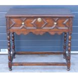 A late 19th century / early 20th century oak side table with single frieze drawer and carved