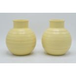 A pair of Wedgwood ribbed vases by Keith Murray in a yellow straw glaze (2). 16cm tall. In good