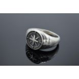 A large chunky silver gents ring with compass-style decoration.