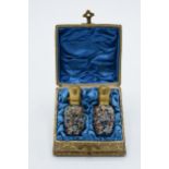 Early 20th century cased pair of hand-painted glass perfume bottles cased in a gilt leather