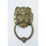 Cast brass door knocker in the form of a lion's head. 21cm long including hoop.