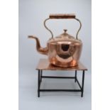 A Victorian copper kettle with brass handle together with copper and metal large trivet (2).