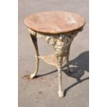 An antique circular cast iron Britannia head pub table with wooden top and metal central support.