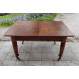 A Victorian extending mahogany dining table on casters with turned supports and 2 additional leaves.