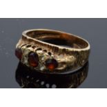 9ct gold textured ring set with 3 garnets. 3.3 grams. Size O/P.