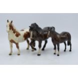 A trio of Beswick horses to include skewbald pinto pony 1373 (af), brown stocky jogging mare 855 and