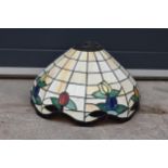 A large Tiffany - style domed lampshade with floral decoration. 45cm diameter.