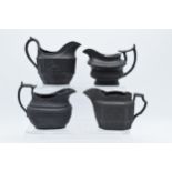 A collection of black basalt milk jugs, circa 1800-1810, to include an oval example sprigged with '