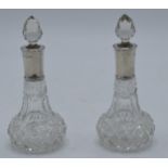 A pair of silver-rimmed glass scent bottles, Chester 1912. 12cm tall.