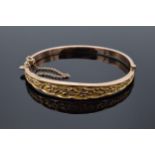 9ct gold ladies bangle with engraved decoration and safety chain. 6.9 grams.