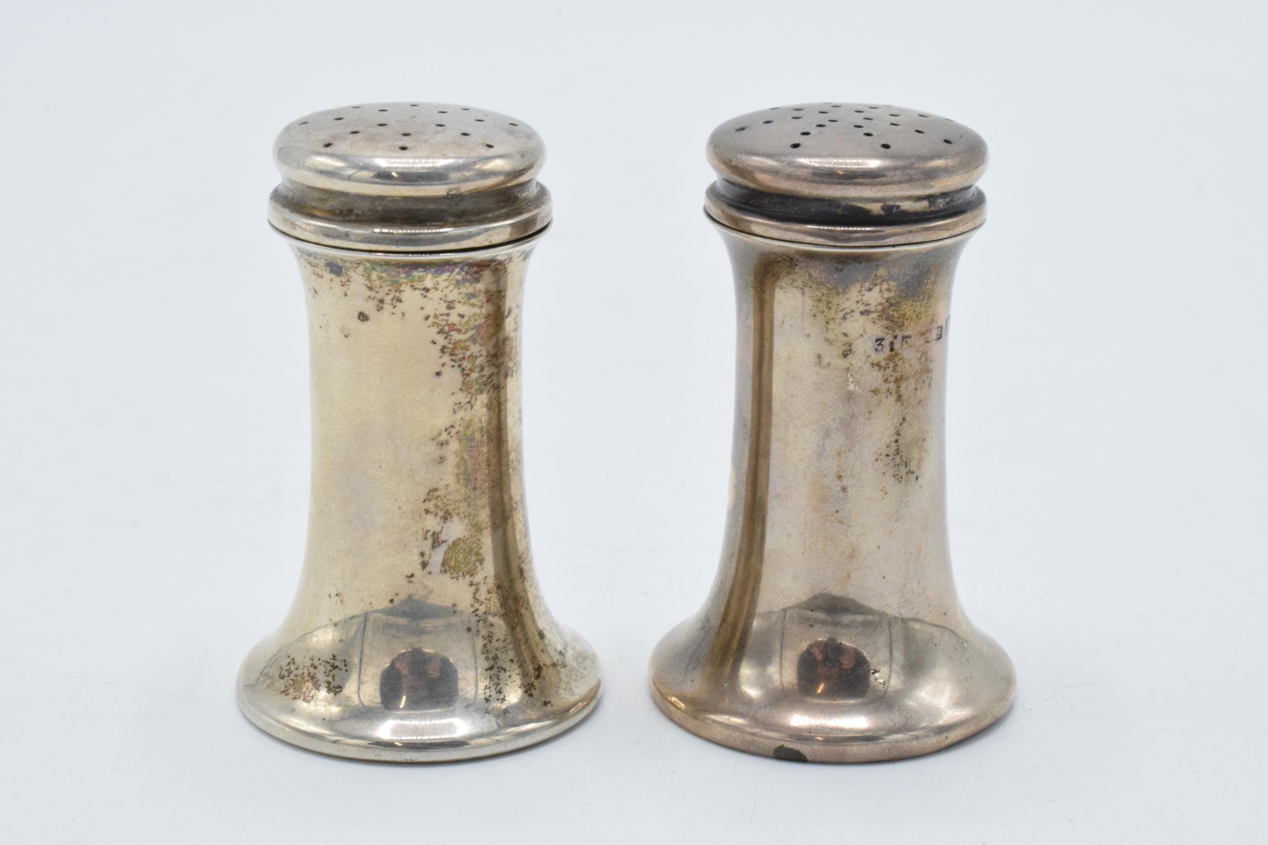 A pair of silver shakers 48.7 grams. Birmingham 1911. 6cm tall.