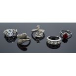 A collection of silver rings of varying styles (4 silver and 1 metal). 14.6 grams excluding metal