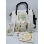 A collection of Beatrix Potter collectables to include a Peter Rabbit handbag, cushion with pin