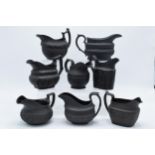A collection of early 19th century black basalt jugs to include a Wedgwood cream jug along with 7