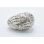 A silver nut-shaped storage capsule for spice / nutmeg etc with repousse decoration and