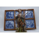 A Capo Di Monte figure of a huntsman with a dog and a framed set of continental Delft-style tiles (