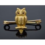 15ct gold pin brooch in the form of an owl on branch set with glass eyes on gold brooch. 2.8