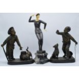 A pair of bronzed spelter figures in the form of boys with animals and a Art-Deco style resin figure