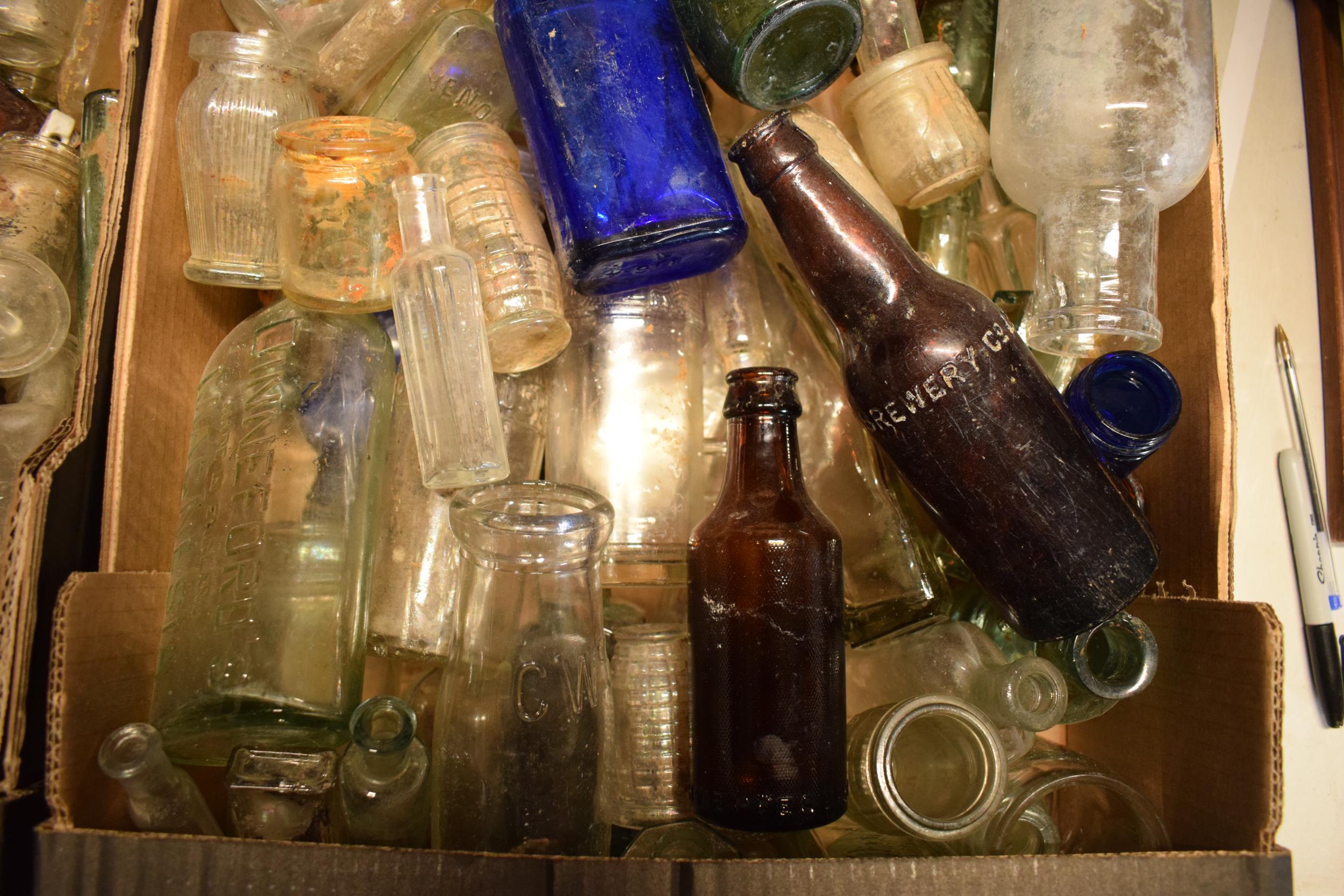 A large collection of glass bottles of varying forms and colours with some having advertising - Image 4 of 4