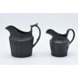 A pair of late 18th century basalt milk jugs, one hvaing moulded faceted oval body and of decorative