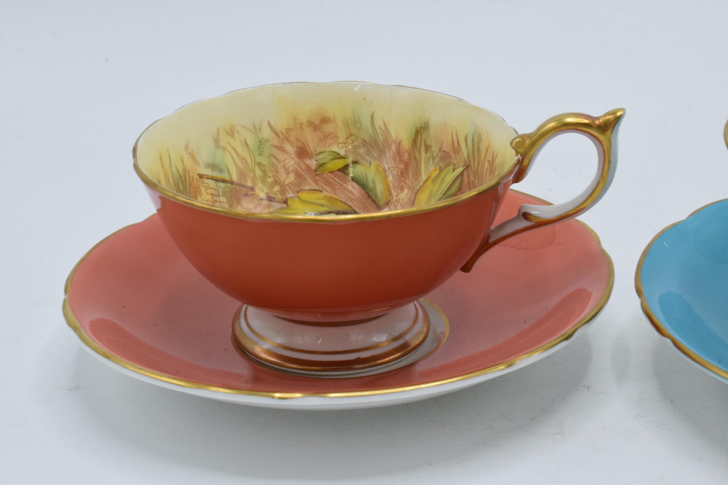 A pair of Aynsley Orchard Gold cups and saucers with coloured backgrounds, both signed D. Jones (4). - Bild 5 aus 8