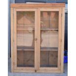 An early 20th century tall pine display cabinet with glazed doors, 106x35x139cm tall. In good