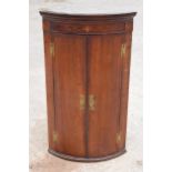 A Georgian oak bow-fronted corner cabinet with inlaid decoration and shelves to interior and