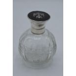 A silver topped globular glass scent bottle with inlaid tortoiseshell lid, London 1916, 12cm tall.