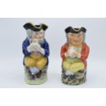 A pair of late 19th century Staffordshire Toby jugs of similar form with each gent having crossed