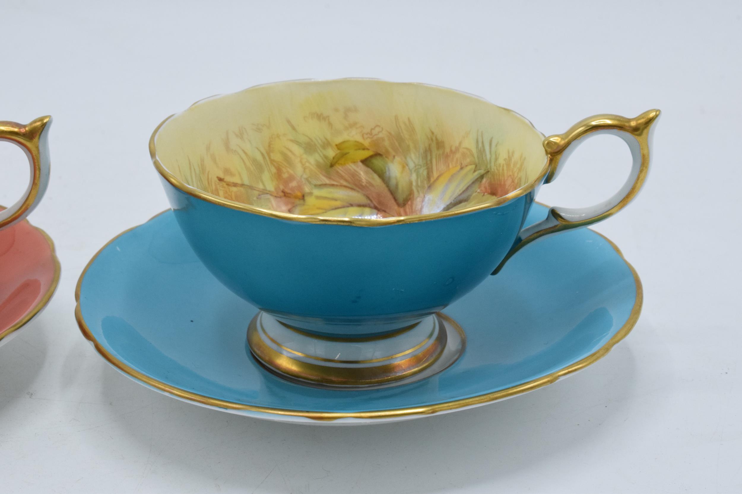 A pair of Aynsley Orchard Gold cups and saucers with coloured backgrounds, both signed D. Jones (4). - Bild 4 aus 8