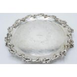 A large silver plated salver raised on three ornate feet with unusual decoration. 26cm wide.