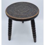 19th century traditional carved oak milking stool on three turned legs, 31cm tall.