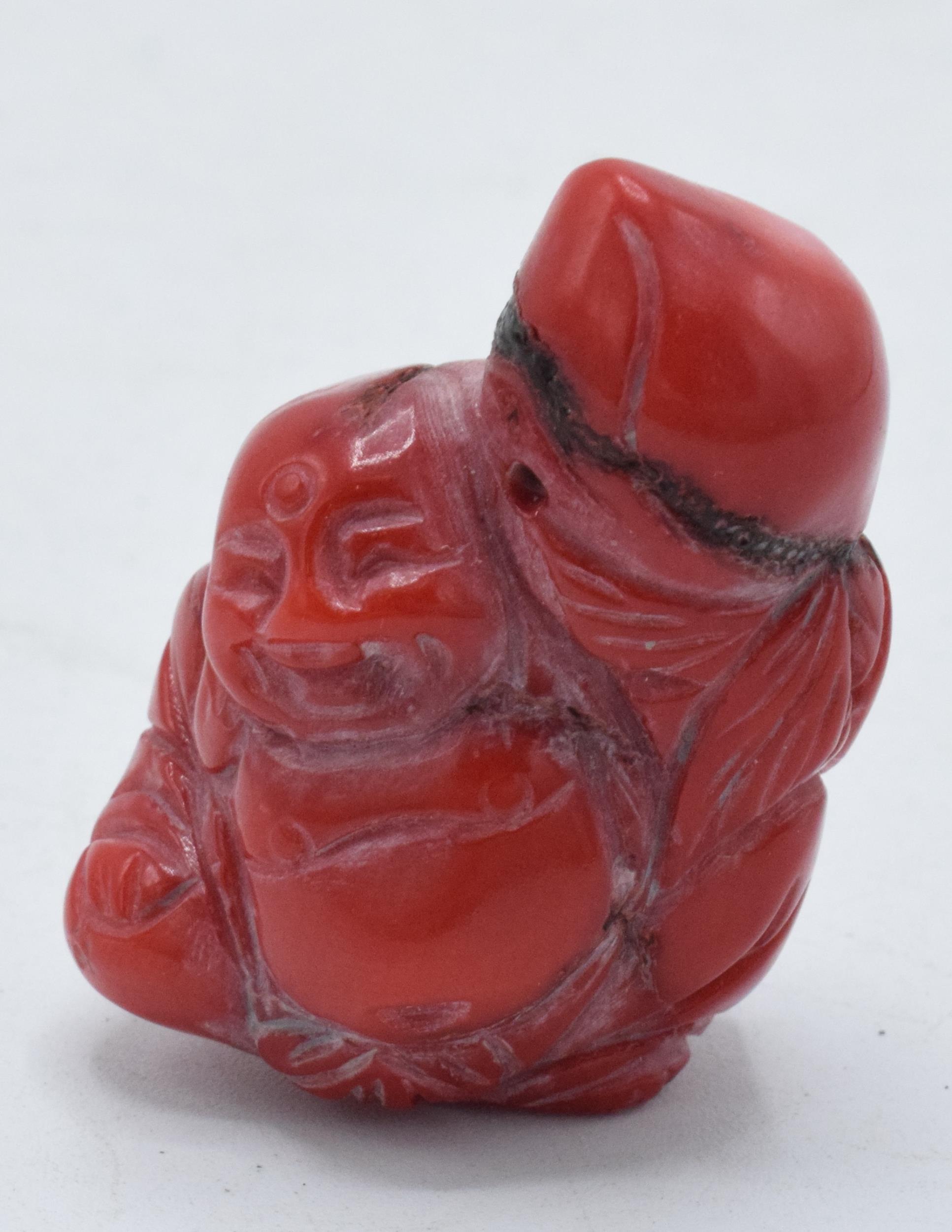 Red hard stone Netsuke type toggle with small pierced hole through top section, 4cm tall.