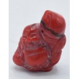 Red hard stone Netsuke type toggle with small pierced hole through top section, 4cm tall.