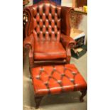 Vintage button back oxblood red leather wingback Chesterfield chair together with footstool, chair