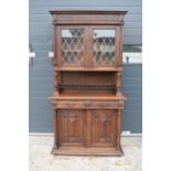An early 20th century wooden kitchen dresser with glazed upper doors and carved decoration. 218cm