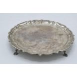 Silver salver, circular form with shaped edges standing proud on 4 feet. 235.5 grams / 7.57 oz.