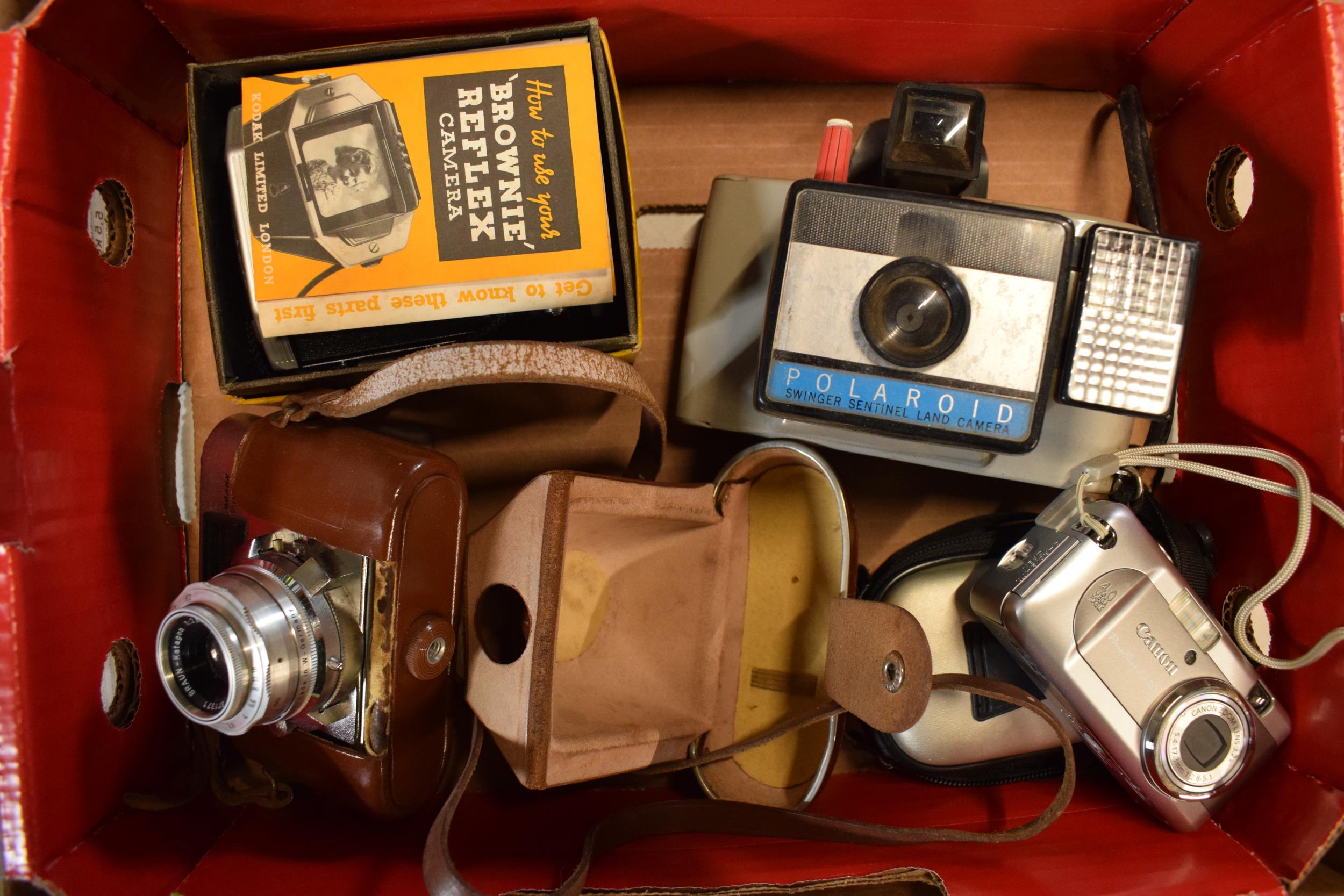 A collection of cameras to include Brownie Reflex in box, Polaraid, Braun Poxette and one later