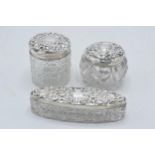 A trio of Edwardian hallmarked silver lidded glass jars to include Chester 1911, 1905 and Birm